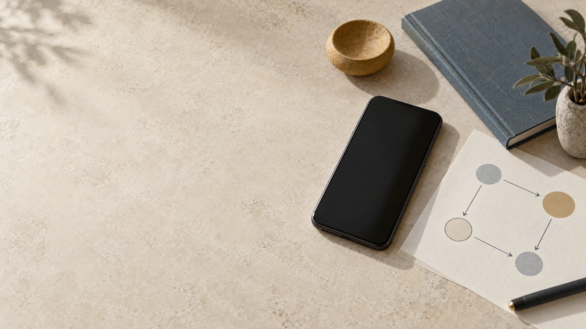 Unbranded phone, notebook and abstract routing diagram on a pale stone desk